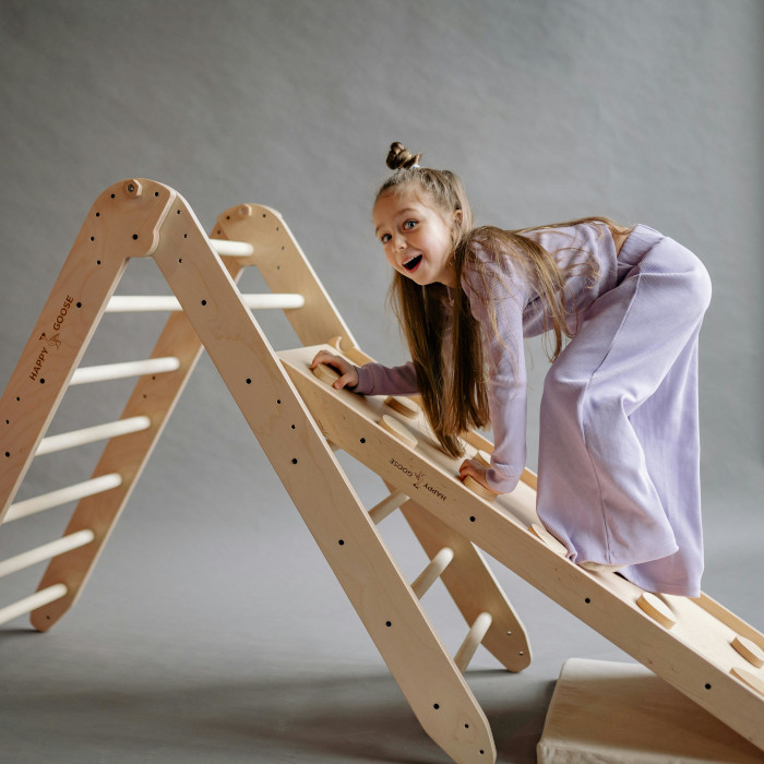 Enfant qui joue avec un triangle Pikler